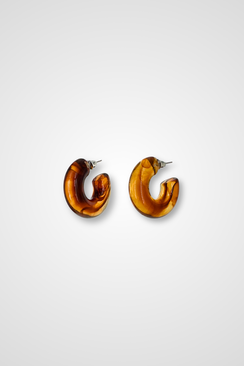 A pair of hoop earrings in a translucent brown with a marble pattern. Chunky design in plastic